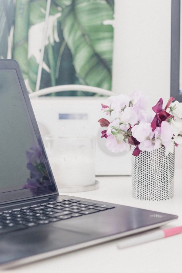laptop on desk with flowers